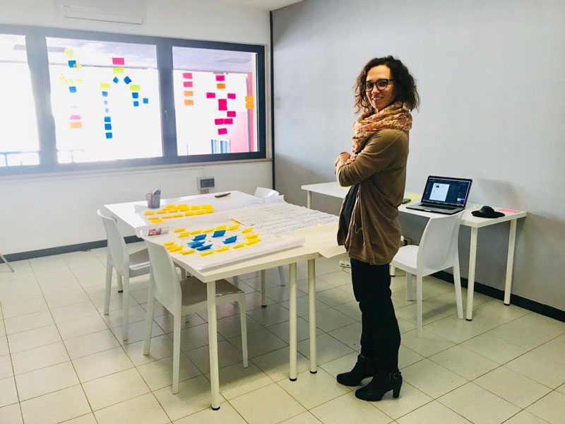 Chiara Danese di didardo in un'aula di Treviso preparata per un workshop di Design Thinking, con post-it alle pareti